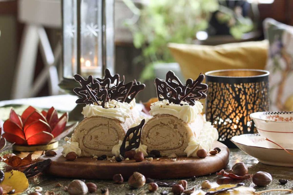 Mockafylld rulltårta med hasselnötter dekorerade med spritsat grädde och chokladlöv. 