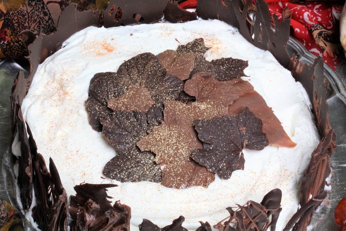 Närbild på Schwarzwaldtårta med chokladlöv som dekoration. 