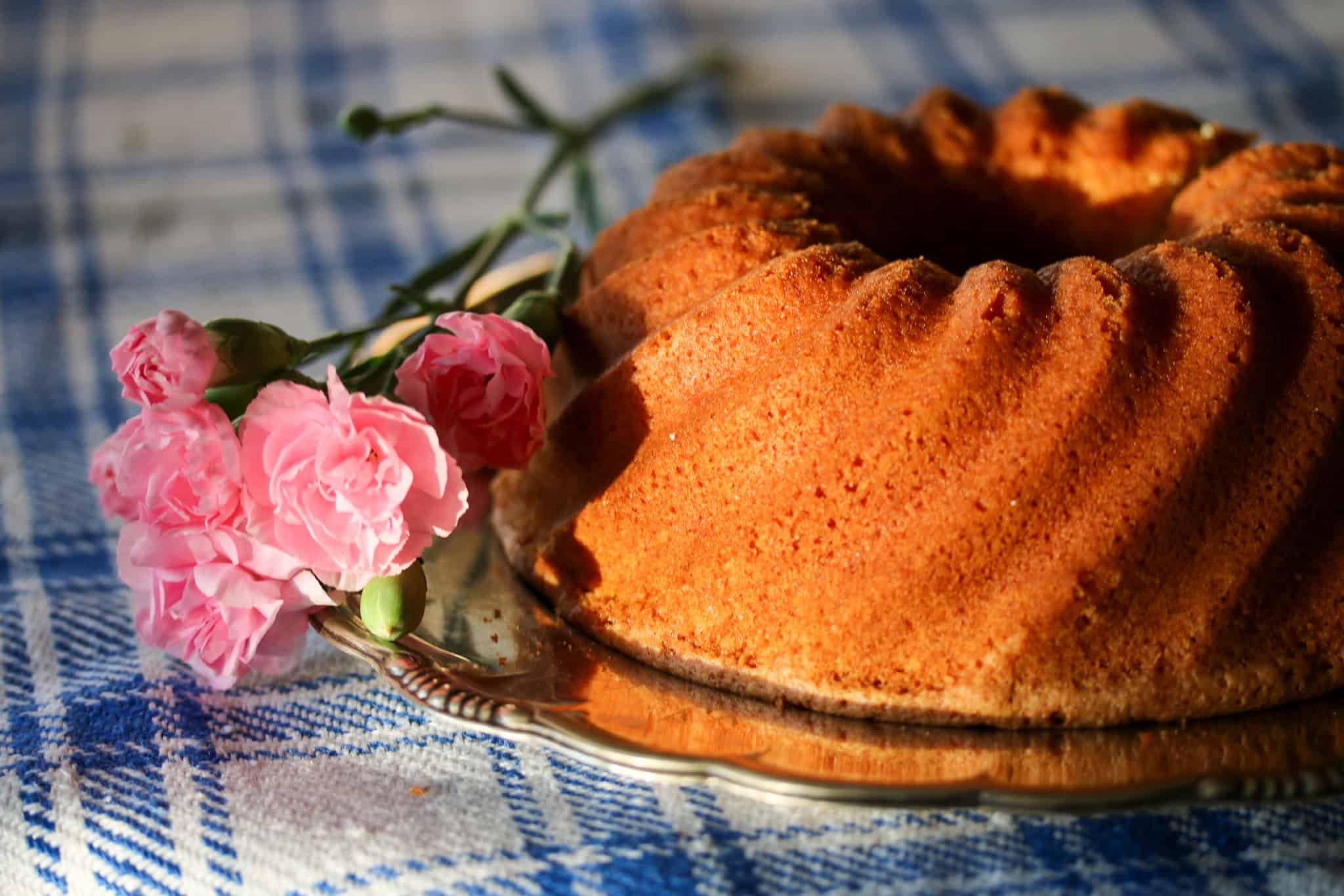 Sockerkaka som heter Favoritkaka i en rund form med rosa blommor vid sidan om.